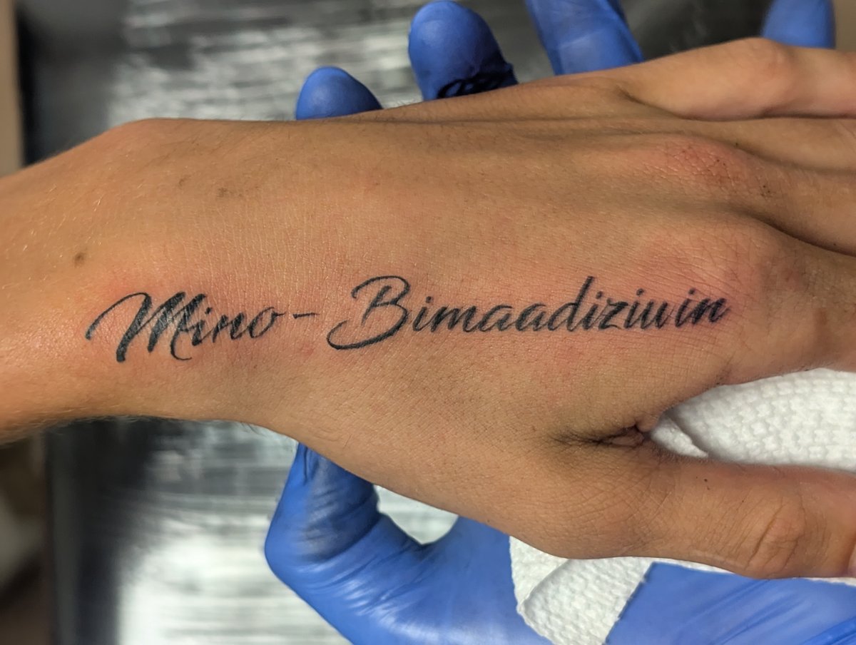Fresh cursive script tattoo across the hand by Shawn Lowe at Fargo Tattoo in Fargo, North Dakota