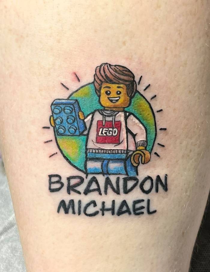 Full color Lego minifigure custom tattoo with Brandon Michael lettering by Shawn Lowe at Fargo Tattoo in Fargo, North Dakota