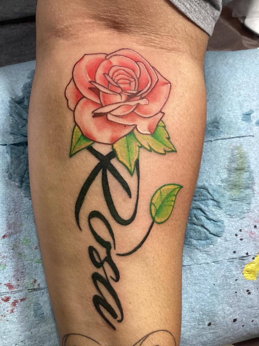 Color rose tattoo with green leaves and black Love script by Shawn Lowe at Fargo Tattoo in Fargo, North Dakota