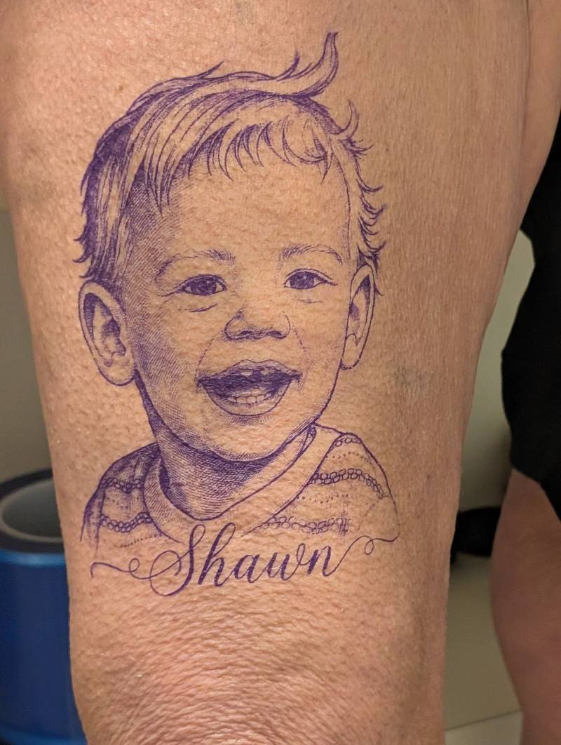 Purple stencil of the child portrait applied to skin before tattooing at Fargo Tattoo