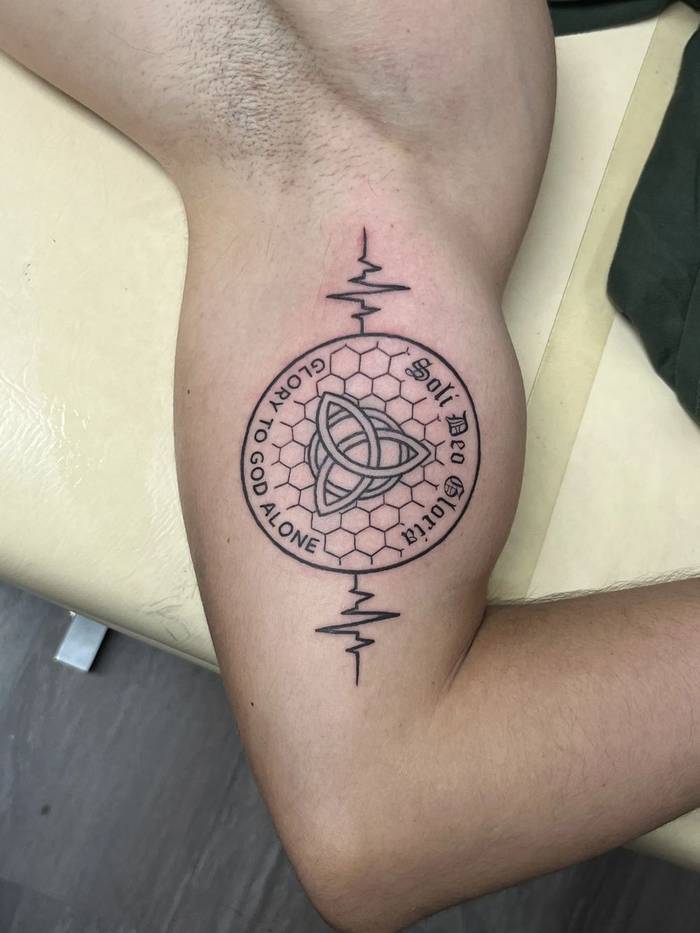 Soli Deo Gloria triquetra honeycomb fine line bicep tattoo by Shawn Lowe at Fargo Tattoo in Fargo, North Dakota